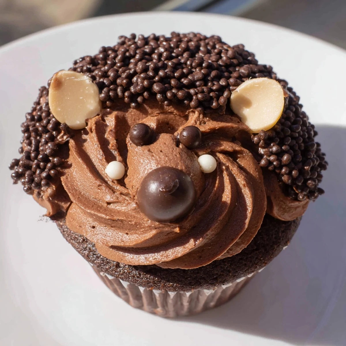 Adorable hedgehog cupcake tower, frosted with chocolate buttercream, ready for a kids' party, is shown.