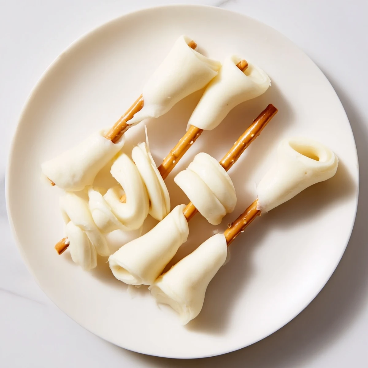 Golden string cheese and pretzel rods form a delightful, quick snack, ready in minutes for kids.