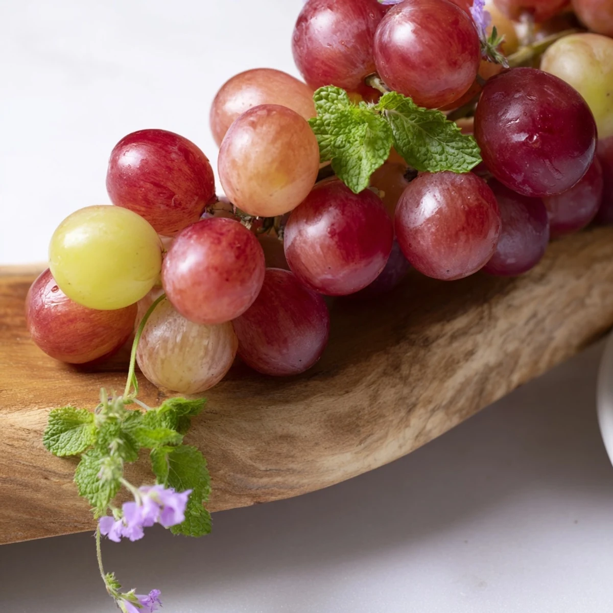 A close-up of a wooden board filled with colorful grapes, ready to serve as a tasty appetizer.