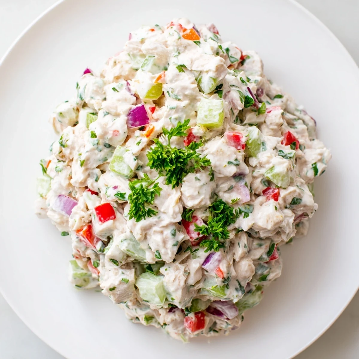Creamy canned chicken salad with vibrant red peppers displayed, ready for serving.