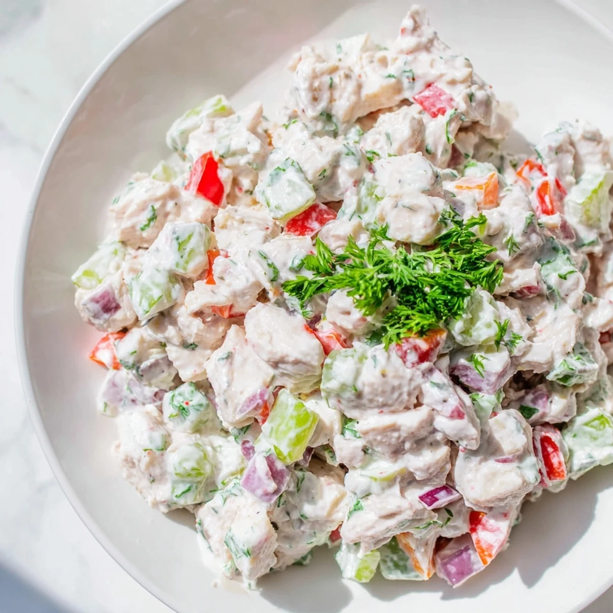 Freshly made canned chicken salad, shown scooped onto a whole-wheat sandwich, delicious!