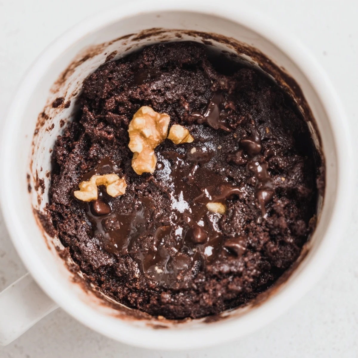 A warm, fudgy mug brownie, still steaming, is ready for a quick chocolate treat.