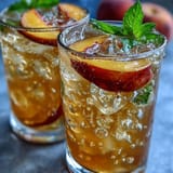 Ein belebender Schluck Iced Peach Green Tea Lemonade, perfekt für sonnige Nachmittage.