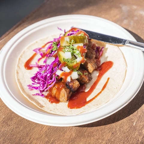 Berlin Currywurst Tacos: a close-up of sizzling sausage nestled in warm tortillas with curry ketchup.