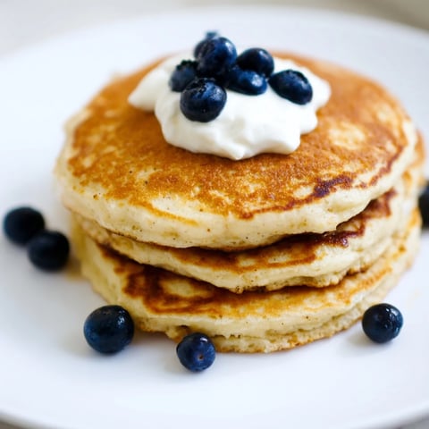 Fluffy golden brown protein banana pancakes ready to be enjoyed with fresh fruit for breakfast.
