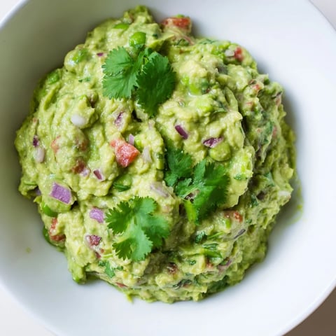 Creamy edamame guacamole, a vibrant green dip with visible chunks, ready to be scooped up.