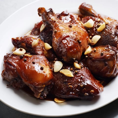 Tender Filipino Chicken Adobo, glistening in a skillet, ready to serve over fluffy white rice.