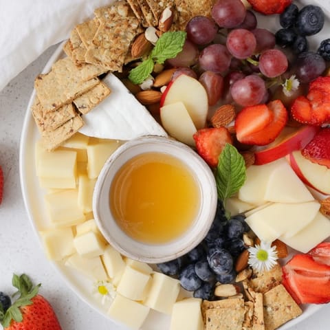 Vibrant Bears Honey Pot Board showcasing fresh fruit, creamy cheeses, and a drizzle of golden honey.