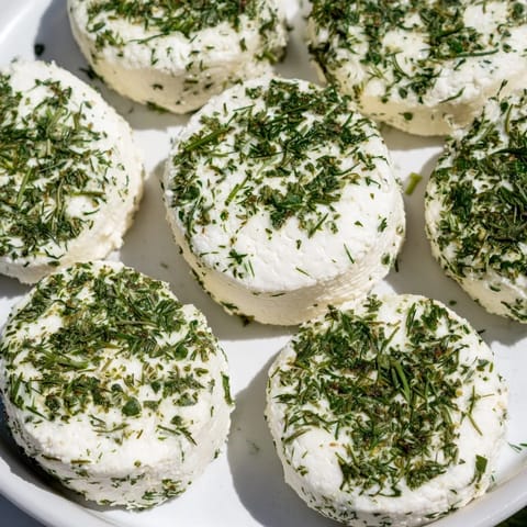Creamy, herb-covered Mossy Stone appetizer, a delightful cheese course with fresh goat cheese and dill.