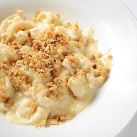 Golden, bubbly Struggle Meal Chicken Macaroni bake, showcasing a creamy cheese sauce over pasta.