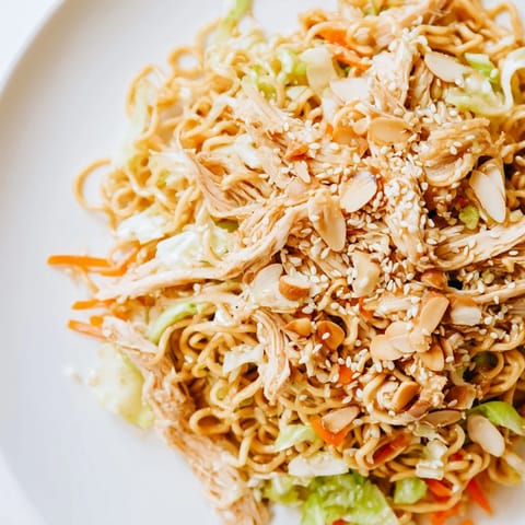 Crunchy Ramen Chicken Salad mit knackigen Nudeln, zarter Hähnchenbrust und knackigem Sesaming-Dressing auf einem Teller.