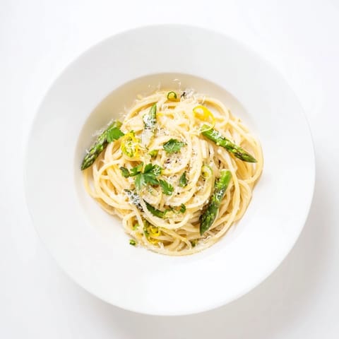 Plated Roasted Garlic & Asparagus Pasta with fresh parsley and lemon zest, ready to serve for a spring dinner.