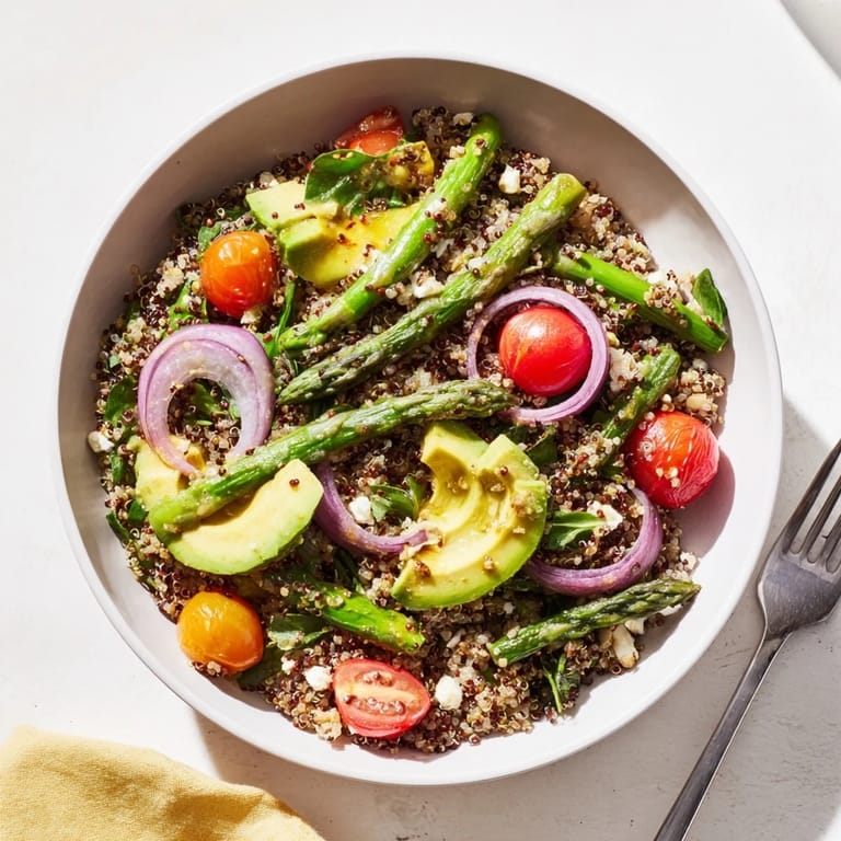 Bunte Quinoa und Spargel Bowl, frisch zubereitet mit Avocado und Kirschtomaten.  