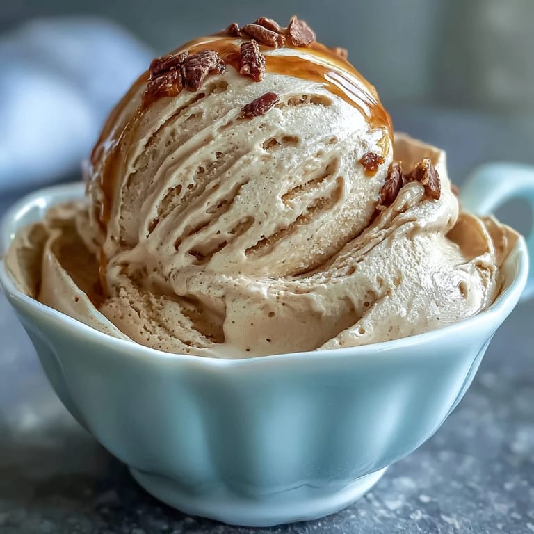 Leicht rauchiges Hojicha Ice Cream in einer keramischen Schale mit Karamell-Topping und Löffel.