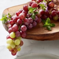 Juicy red and green grapes cascade over the serving board, perfect for a refreshing snack.