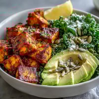 Crispy turmeric tofu, sautéed kale and creamy avocado in a vibrant breakfast bowl topped with pumpkin seeds.