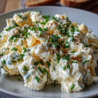 Cremige Protein-Cottage-Cheese-Rühreier mit Kräutern, serviert auf Toast.
